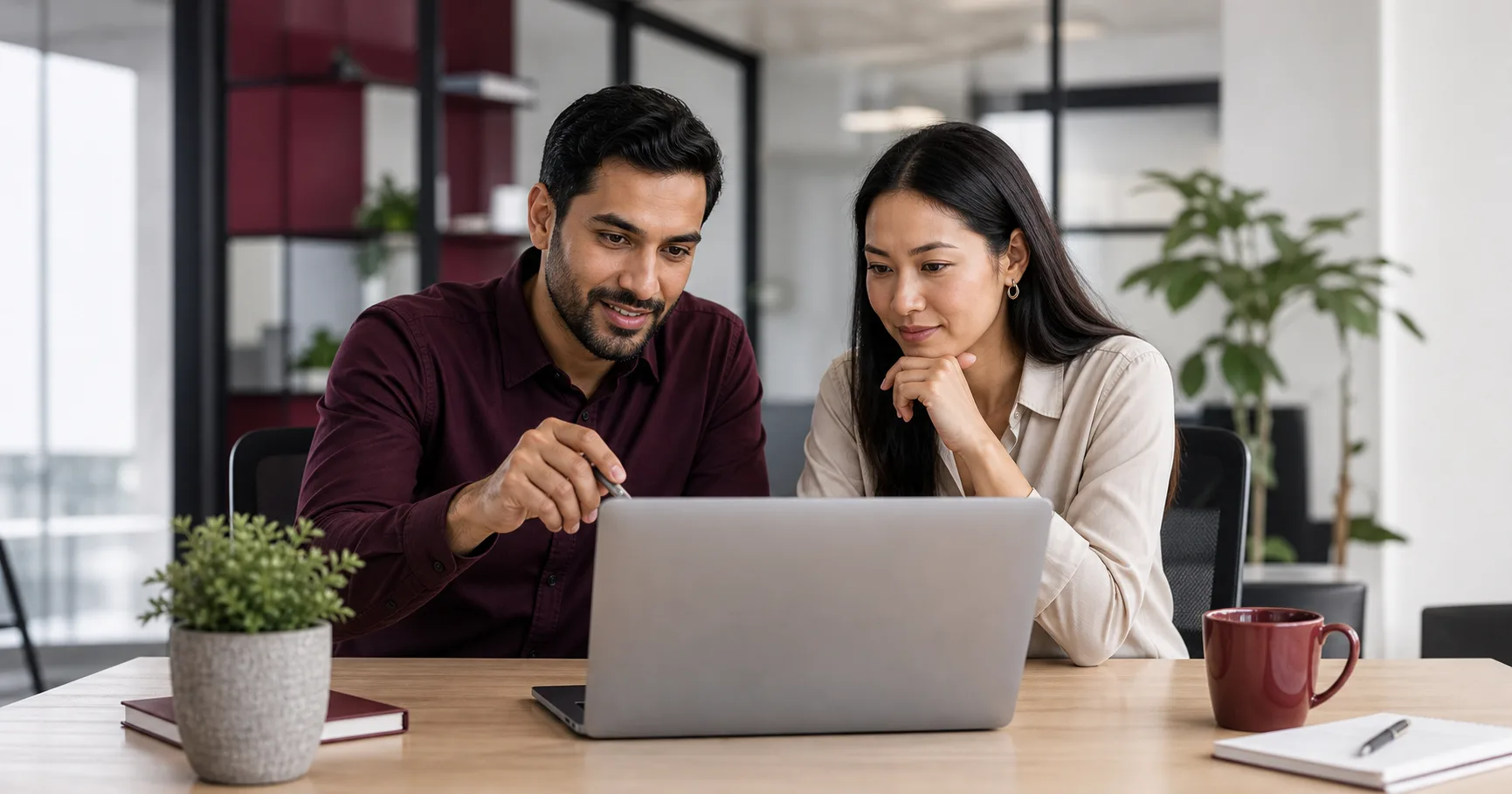 Business owner and technical advisor reviewing a domain registration plan on a laptop